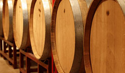 Oak wine barrels shown on racks aging wine